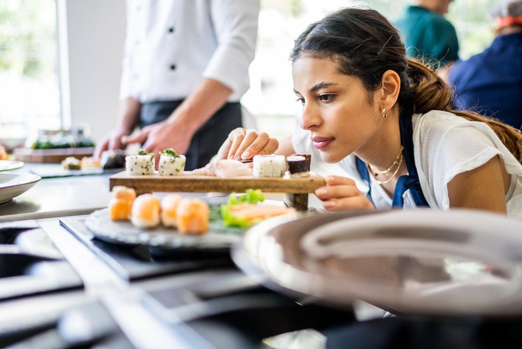 Mujer preparando sushi en la cocina