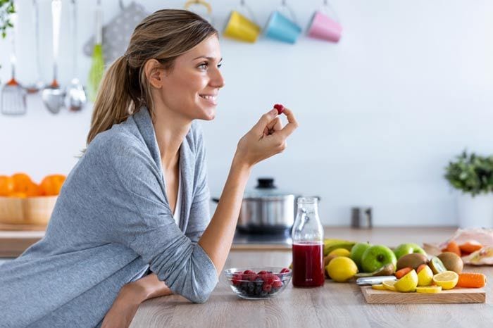 mujer tomando frutas