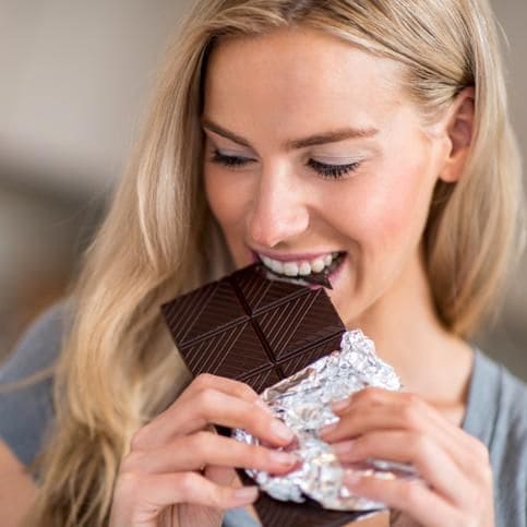 Mujer come una barra de chocolate