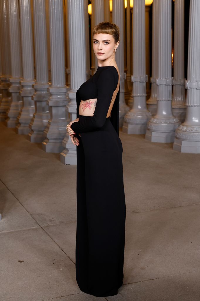 Cara Delevingne posó a su llegada a la Gala LACMA en un vestido negro con un pronunciado escote en la espalda