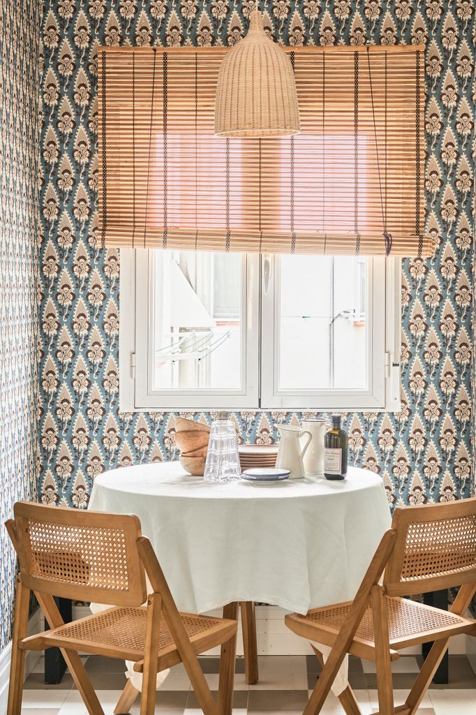 Comedor con paredes de papel pintado y estor de caña