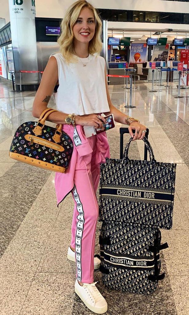 chiara ferragni con maletas y el bolso dior book tote