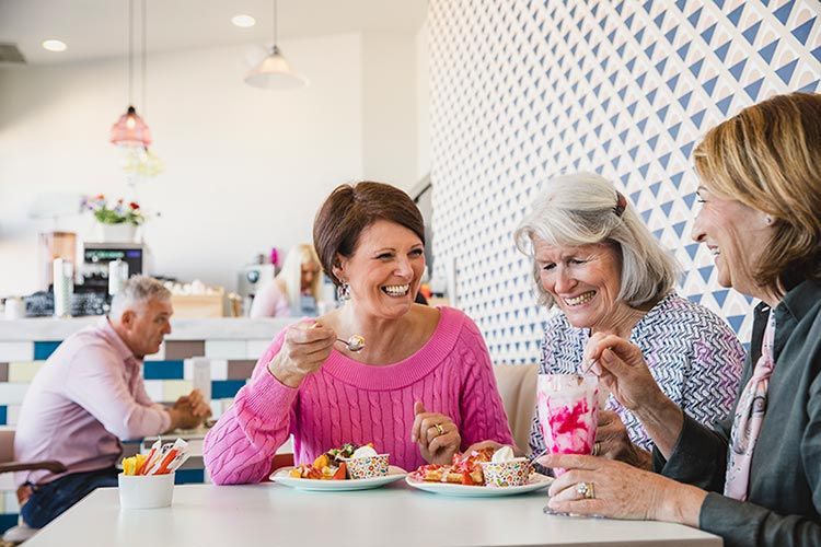 Mujeres disfrutando en una cafetería de un postre