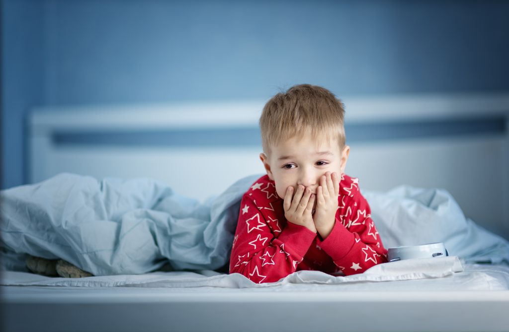 Niño despierto en la cama