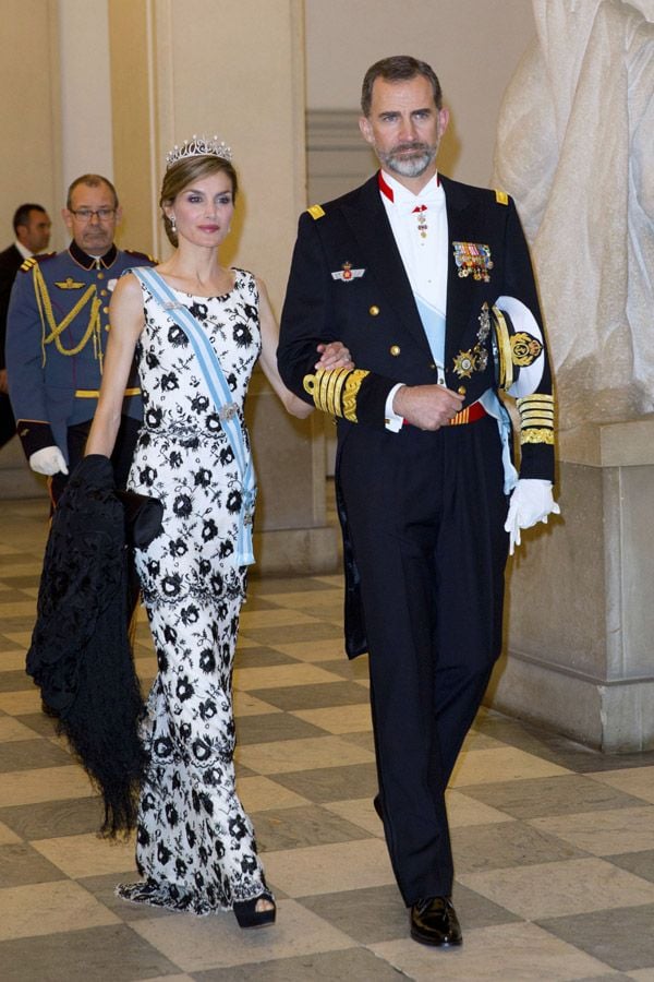 La Reina ha lucido un vestido -cuya falda estaba compuesta por capas terminadas en ondas- blanco y negro con motivos florales. Tanto para los zapatos, tipo peep toes como nos tiene acostumbrados, como para el bolso doña Letizia apostó por el color negro, igual que el mantón de Manila que colgaba en su brazo, listo para protegerse del frío en un noche en el que el termómetro no alcanzó los trece grados en la capital de Dinamarca
