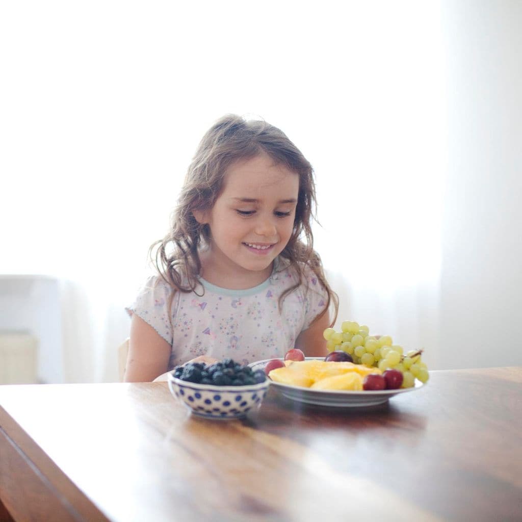 Niña come fruta