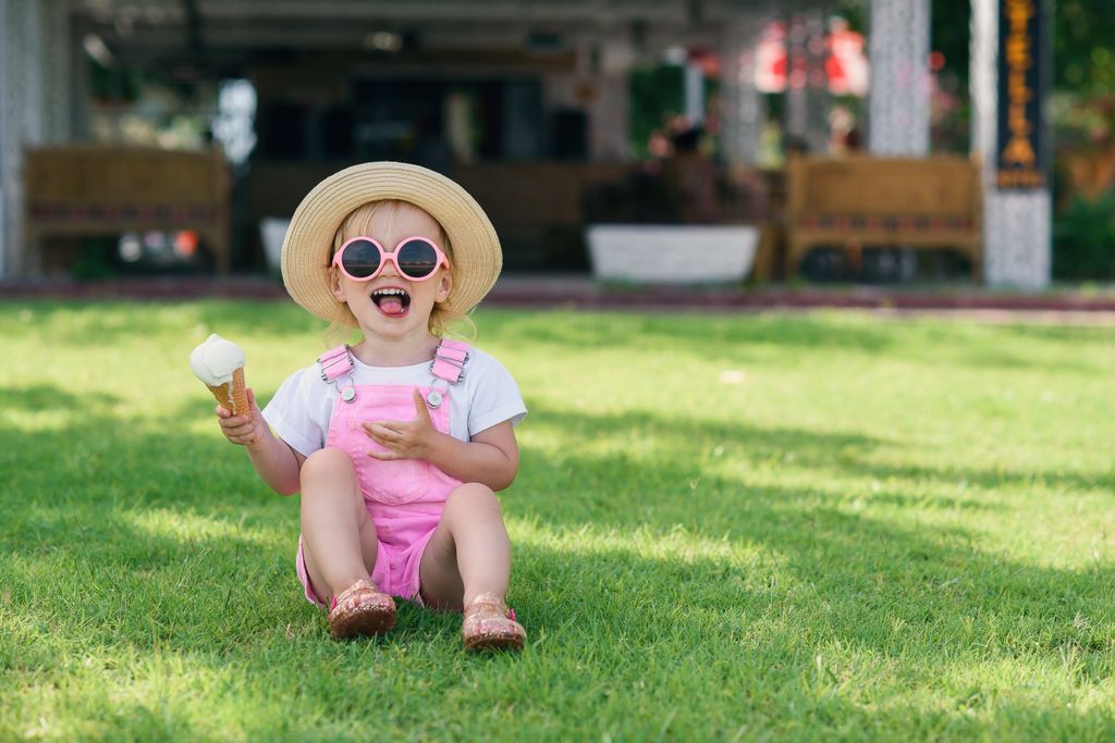 Niña pequeña feliz tomando un helado 