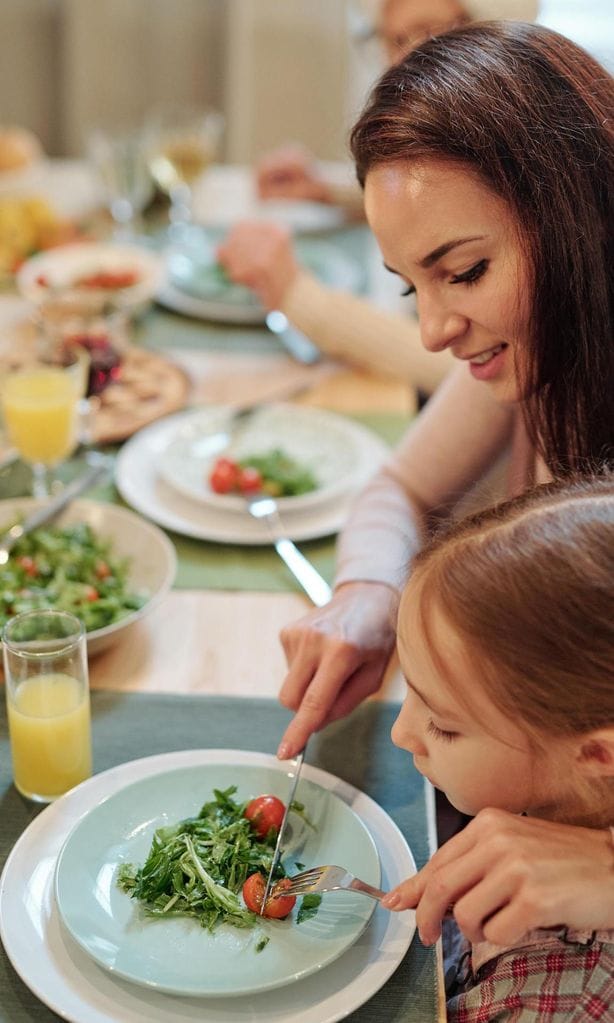 Madre e hija comiendo verdura