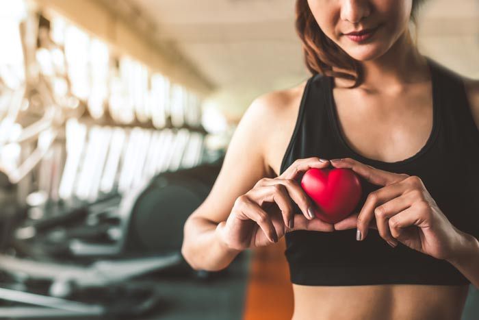 mujer deportista con un corazón en la mano