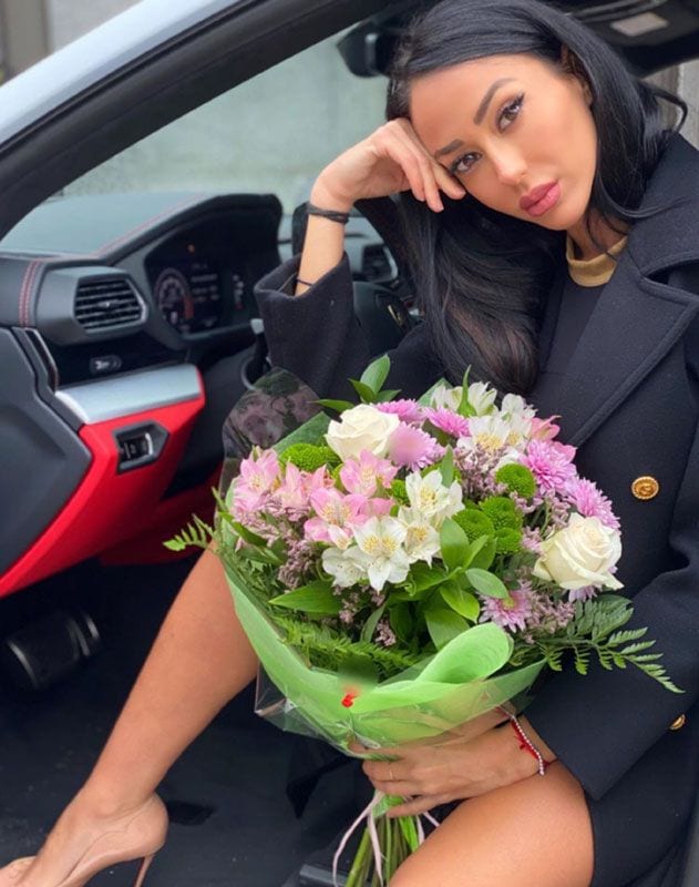 Aurah Ruiz en un coche posando con un ramo de flores