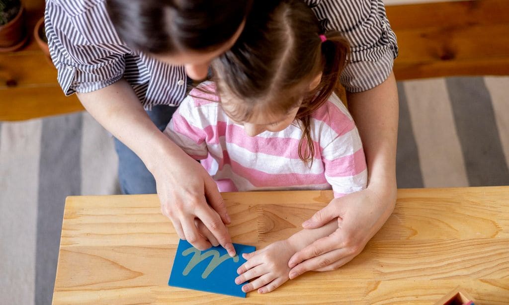 montessori material mom helps her daughter learn letters using the rough alphabet 