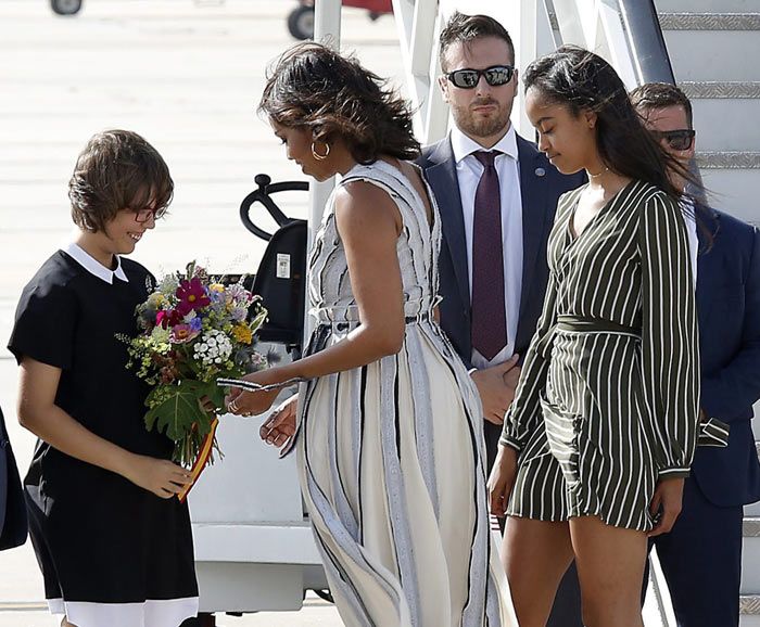 A su llegada una niña de 14 años con discapacidad intelectual y alumna del Colegio de la Fundación Carmen Pardo-Valcarce, entregó a Michelle Obama un ramo de bienvenida, compuesto de alimentos y plantas de la Huerta de Montecarmelo donde trabaja
