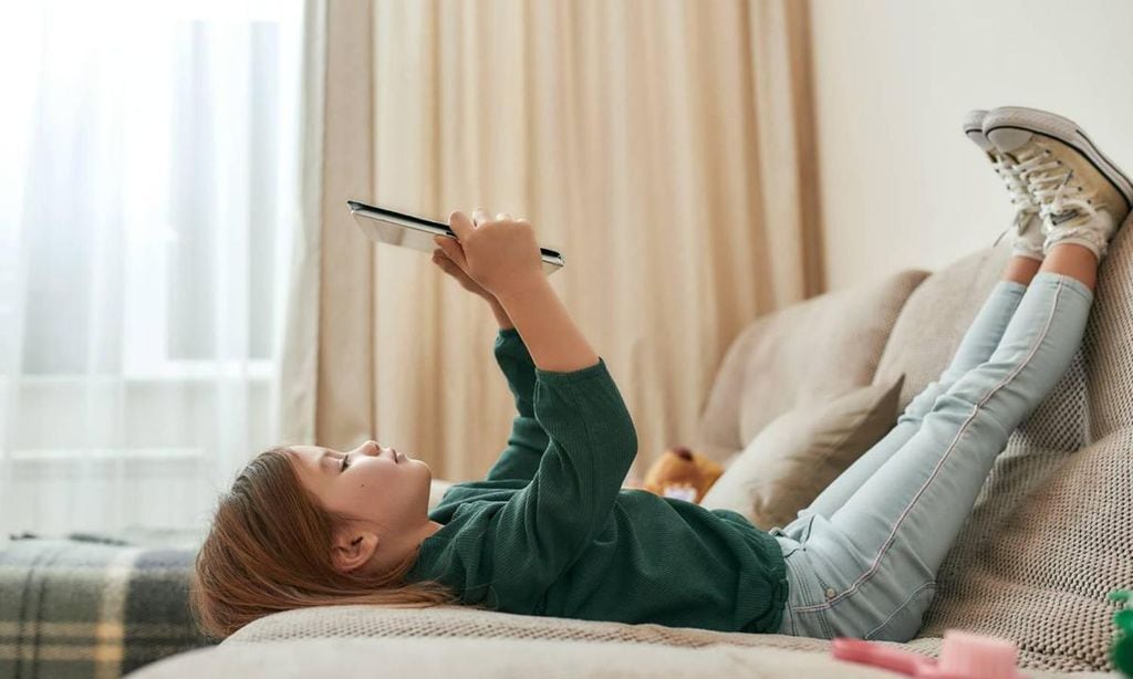 ni a solitaria mirando tablet en su casa