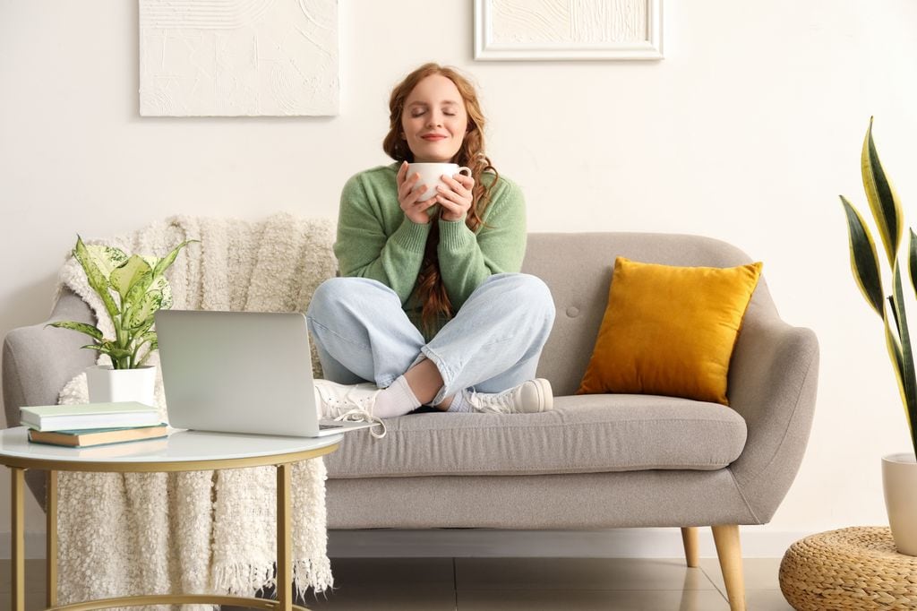 mujer relajada en el sofá tomando una infusión