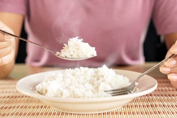 mujer comiendo arroz