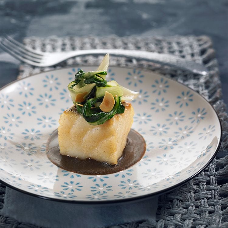 Taco de bacalao con acelgas y almendras sobre emulsión de ajo negro