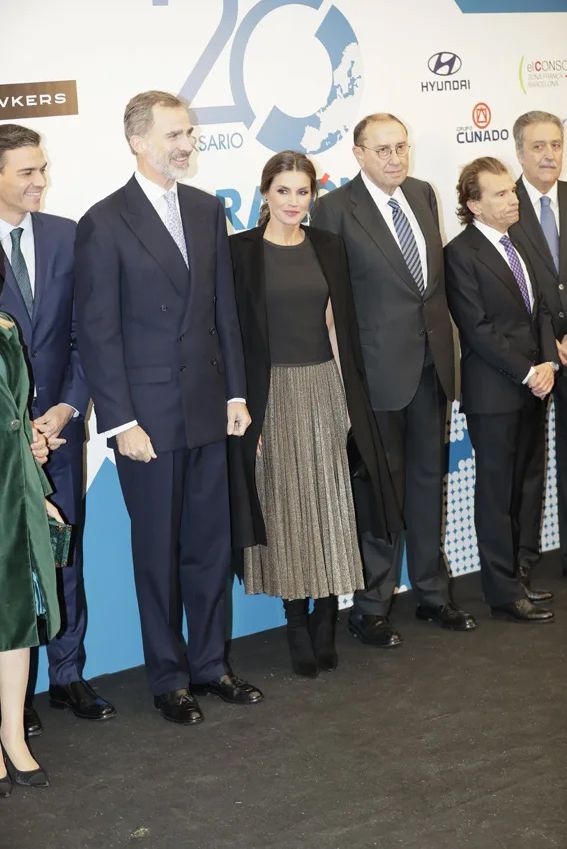 La reina Letizia recicla en Madrid su vestido negro de escote 'bardot' con zapatos de cristales