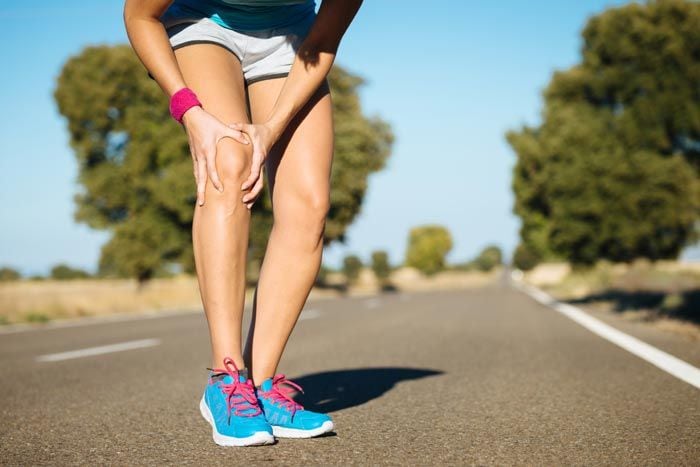 mujer con dolor en la articulación de la rodilla