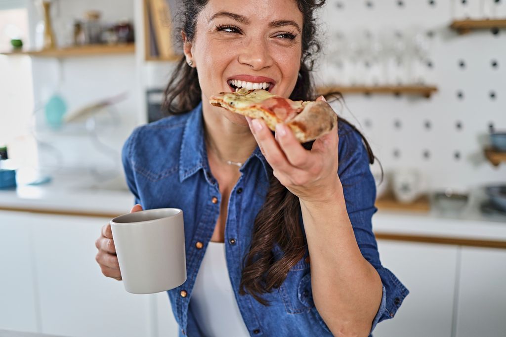 woman eating pizza very smiling