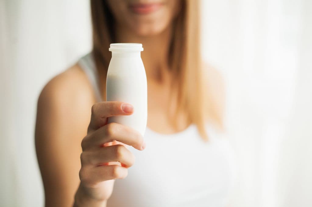 mujer con un yogur líquido en la mano