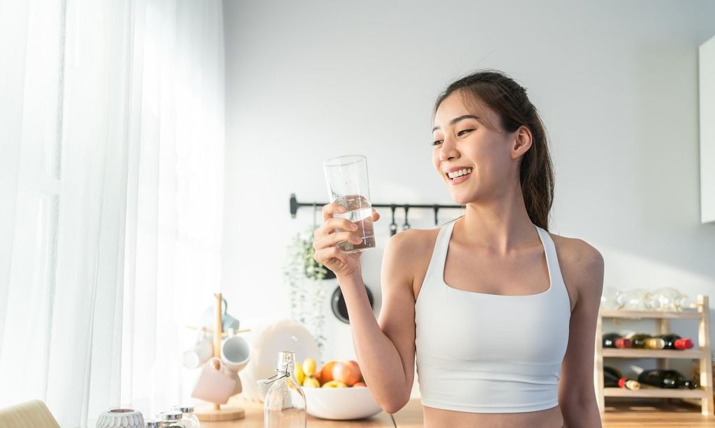 mujer bebiendo vaso de agua