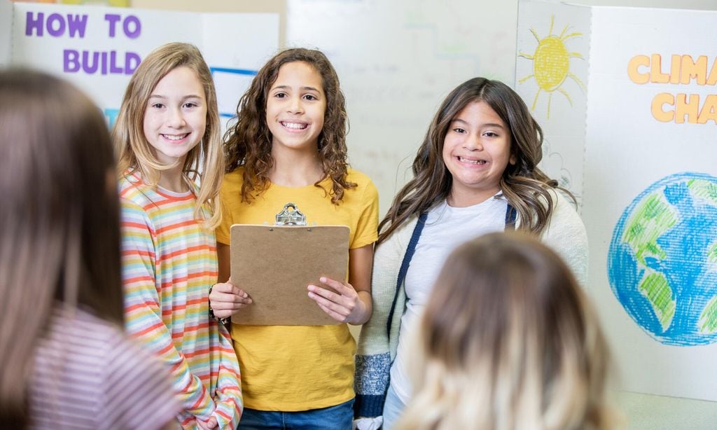 diverse group of elementary school girls presenting their group science fair entry