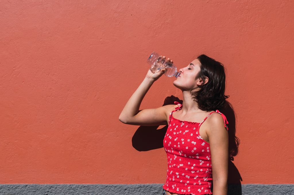 mujer joven bebiendo agua