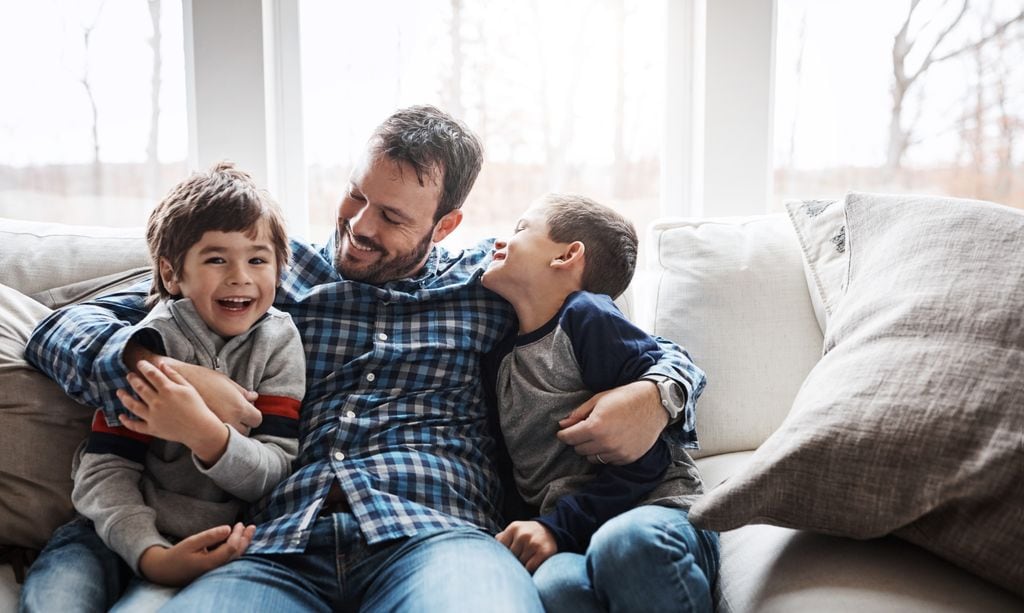 Padre en el sofá con sus dos hijos pequeños