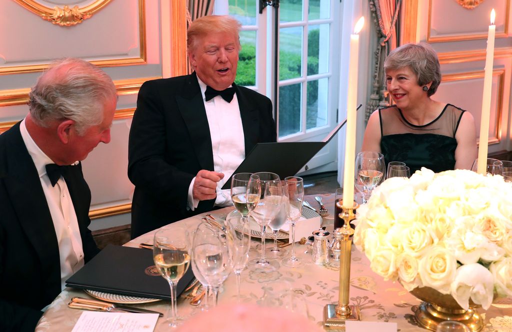 Donald Trump, durante su primer mandato presidencial como 45º Presidente de los Estados Unidos) charla con el rey Carlos III (en ese momento príncipe de Gales) y con la Primera Ministra británica Theresa May en Winfield House