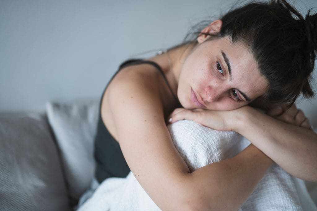 Mujer triste en la cama