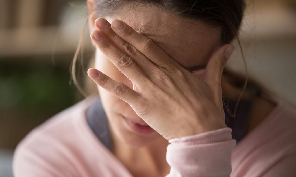 mujer preocupada con mano en la frente