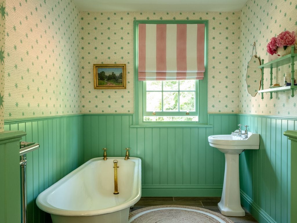 Baño con las paredes revestidas con papel pintado y arrimadero 