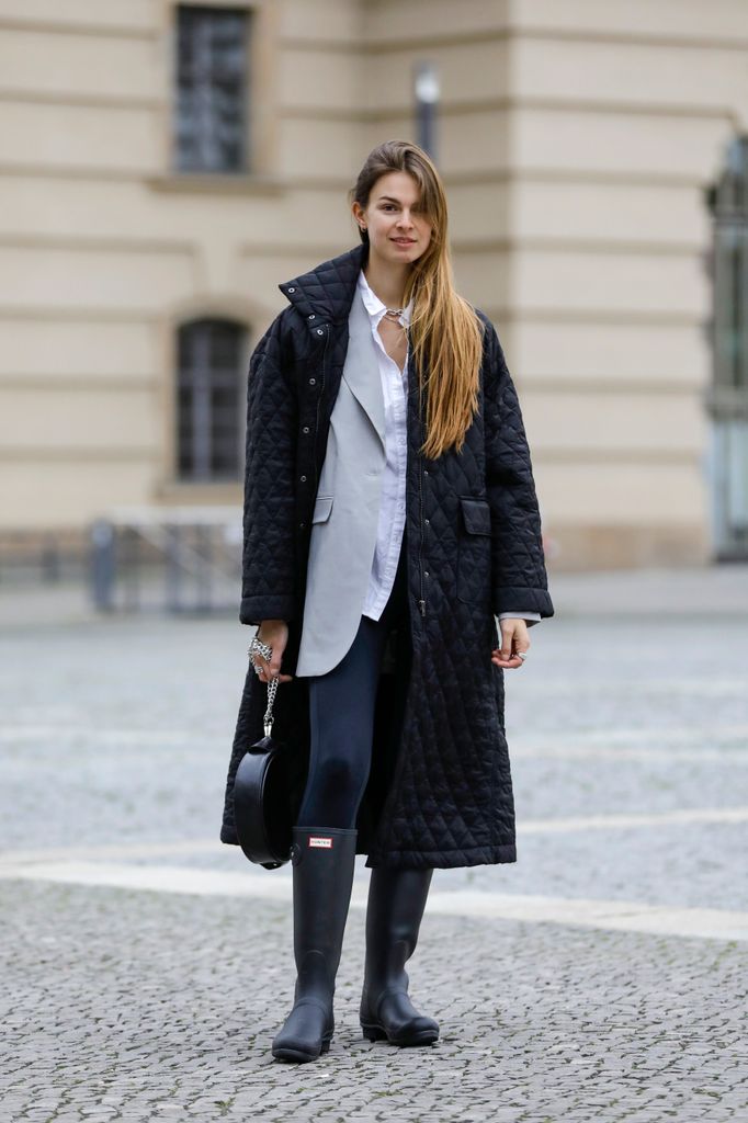 BERLIN, GERMANY - OCTOBER 20: Influencer Jacqueline Zelwis, wearing a long black coat by Birgitte Herskind, a light grey blazer by Birgitte Herskind, a white shirt by Gestuz, dark blue leggings by Zara, black rubber boots by Hunter, a black bag by Liebeskind Berlin and jewelry by Black Palms the Label during a street style shooting on October 20, 2020 in Berlin, Germany. (Photo by Streetstyleshooters/Getty Images)