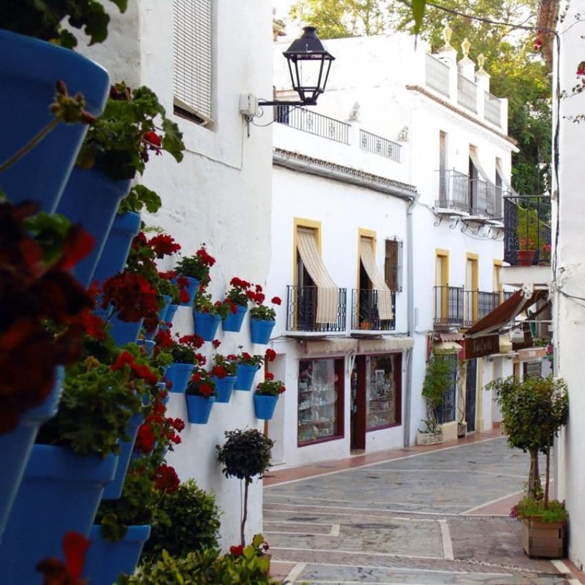 Las macetas de colores llenan las fachadas blancas de las casas en el casco histórico de Marbella.