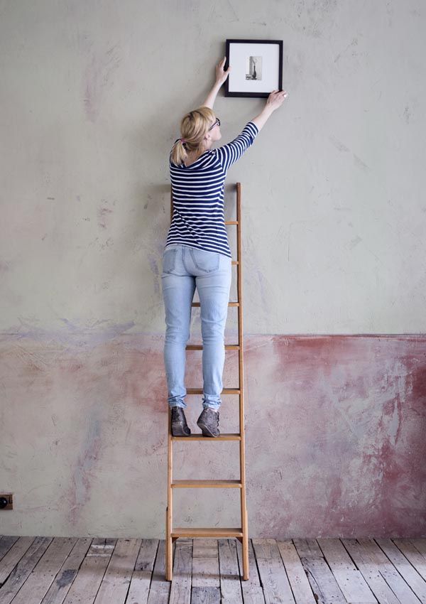 chica colocando foto pared