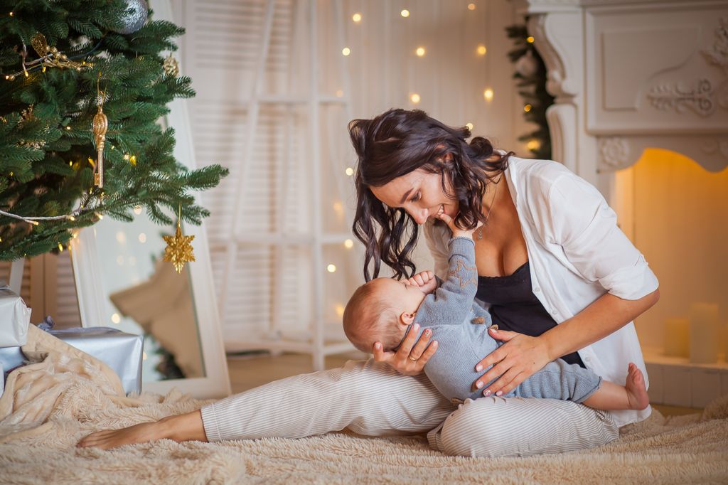 Madre con su bebé en una escena de Navidad