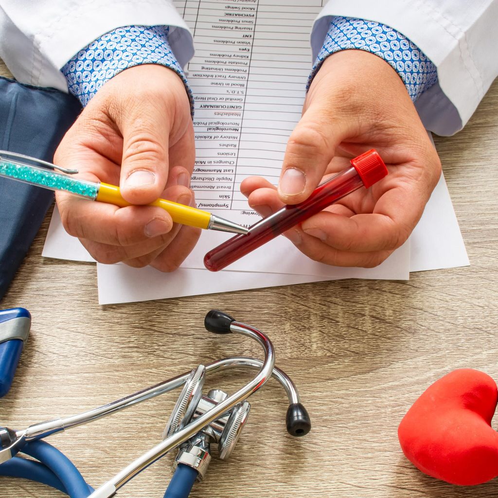 Doctor during consultation held in his hand and shows patient laboratory tube with blood. Counseling of transfusion, blood and hematologic diseases and pathology like anemias, cell cancer, hemophilia