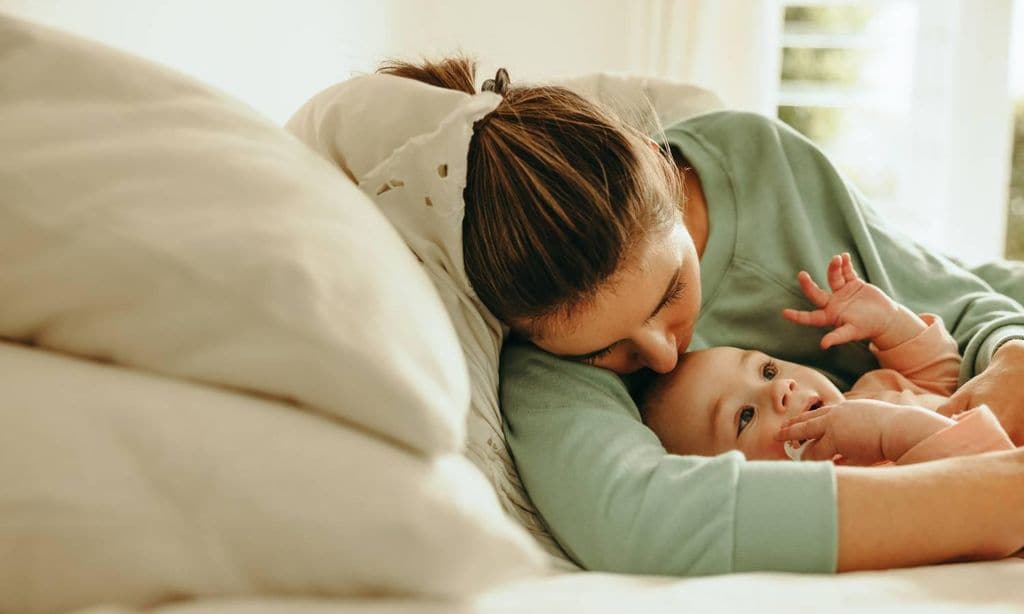 madre dormida en el sof con su hijo reci n nacido en brazos