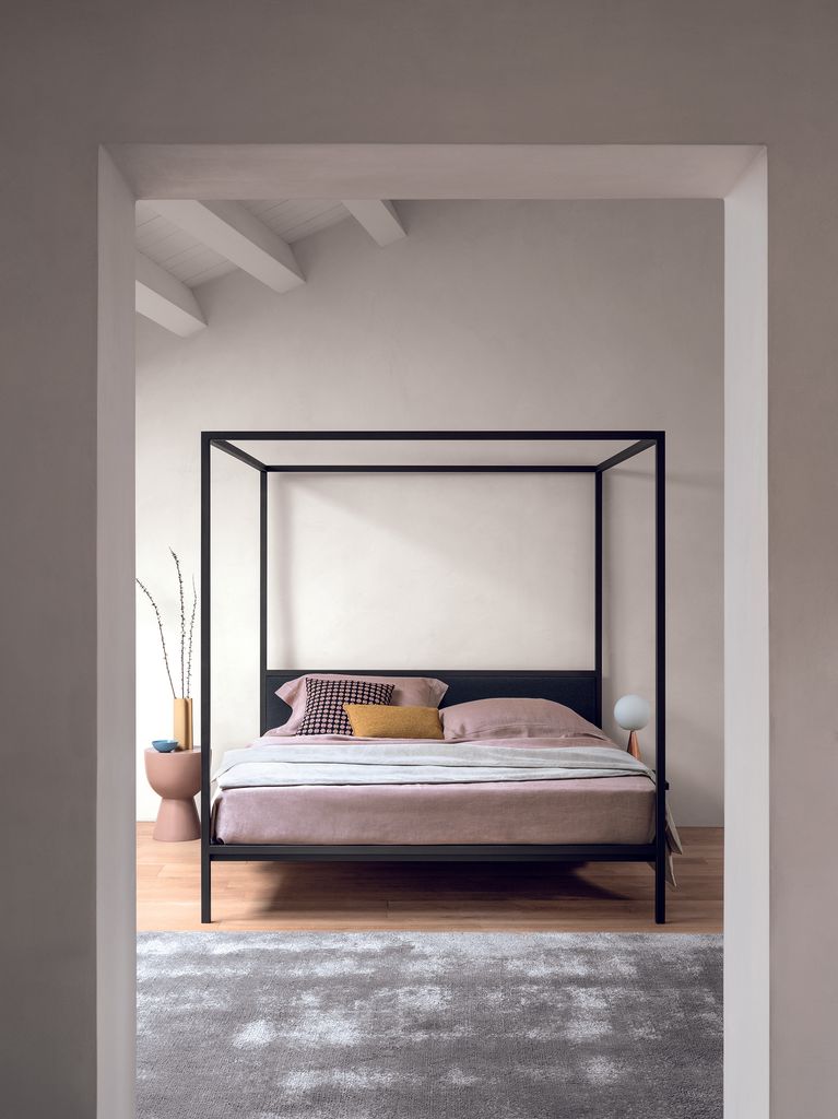 Dormitorio minimalista con cama con dosel