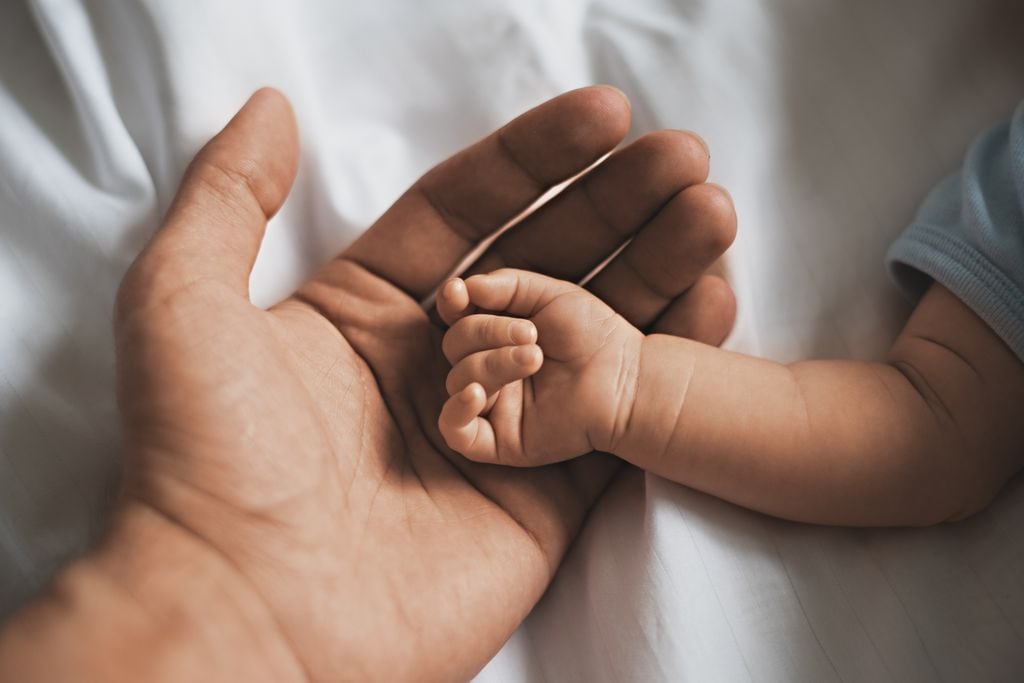 Mano de un bebé con su padre