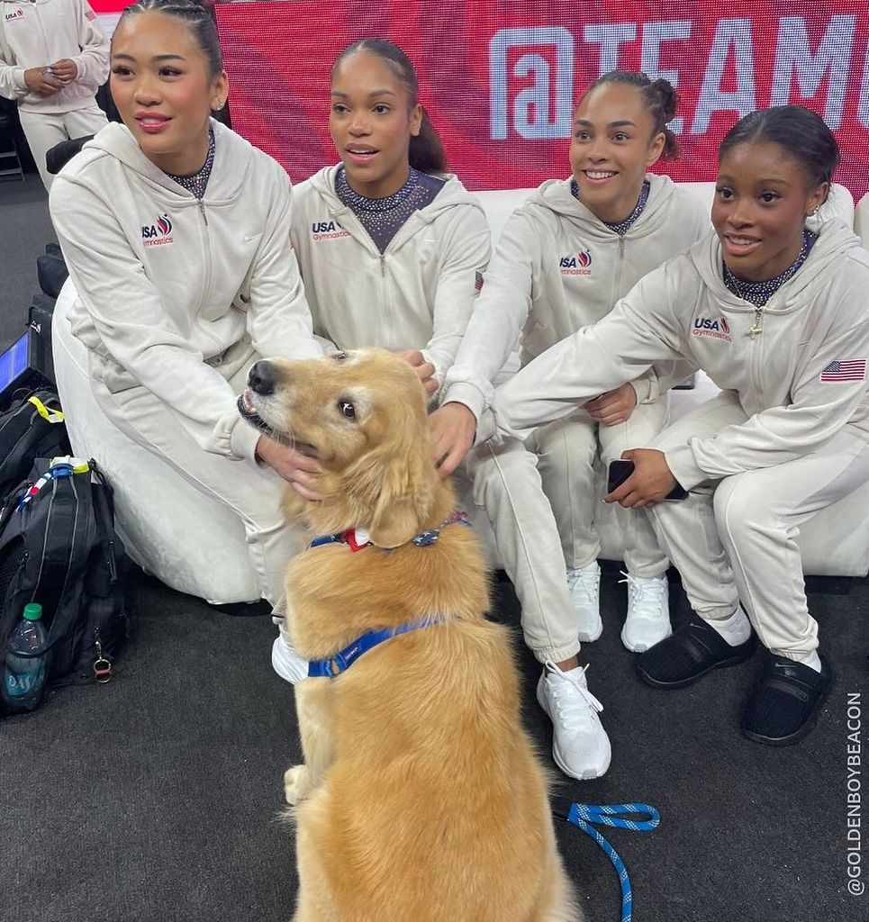 Gimnastas estadounidenses junto a Beacon, el perro de terapia del USAG