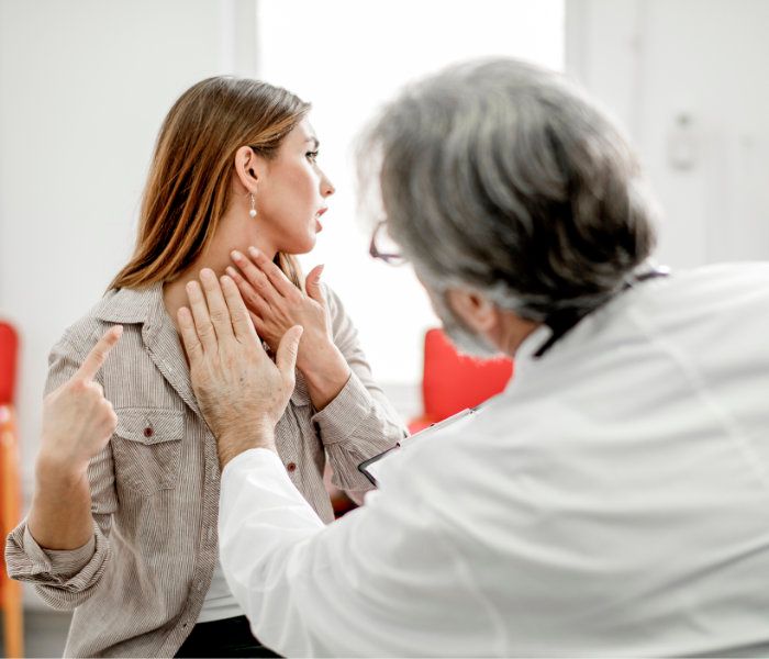 mujer en el médico consultando un bulto en el cuello