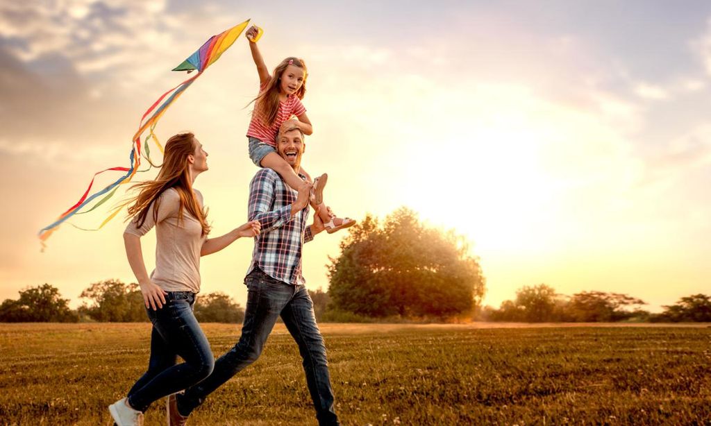 familia feliz volando cometa en la playa