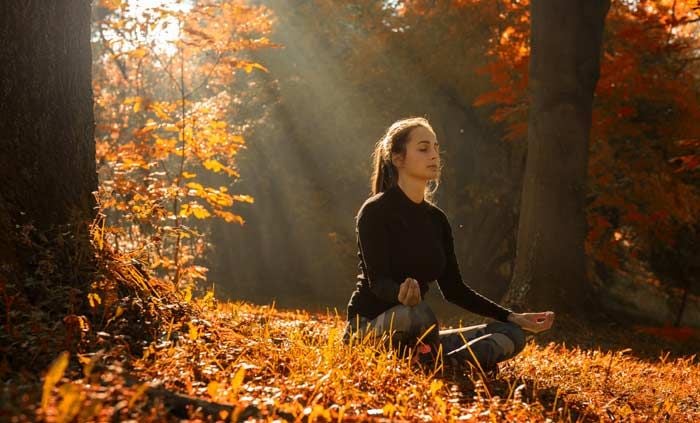 mujer meditando en otoño