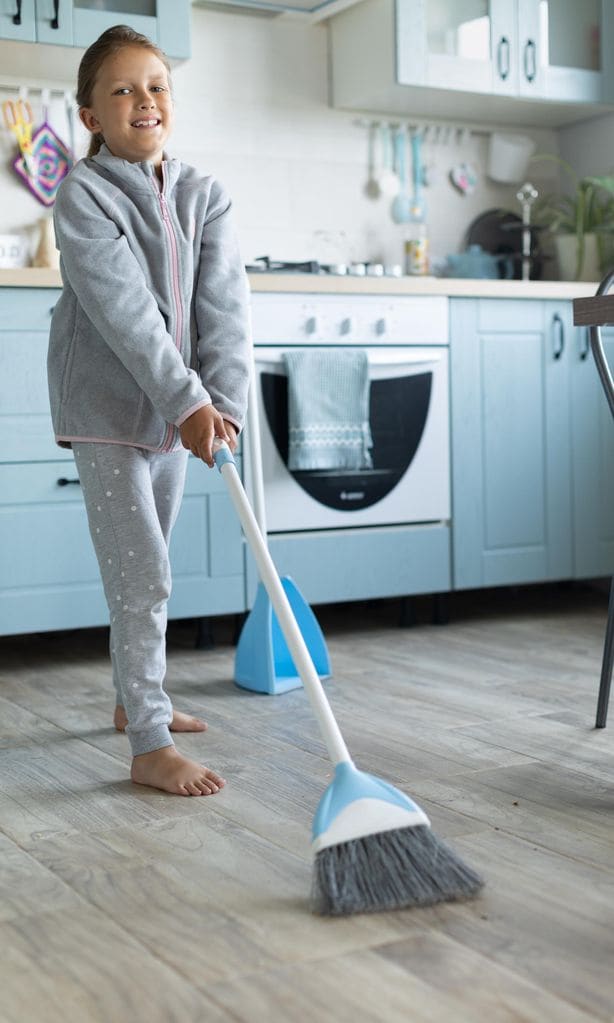 Niña barriendo la cocina