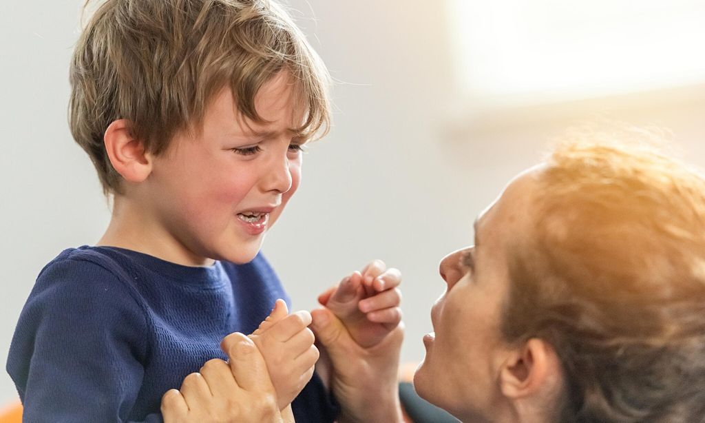 Little boy crying being consoled by his mom