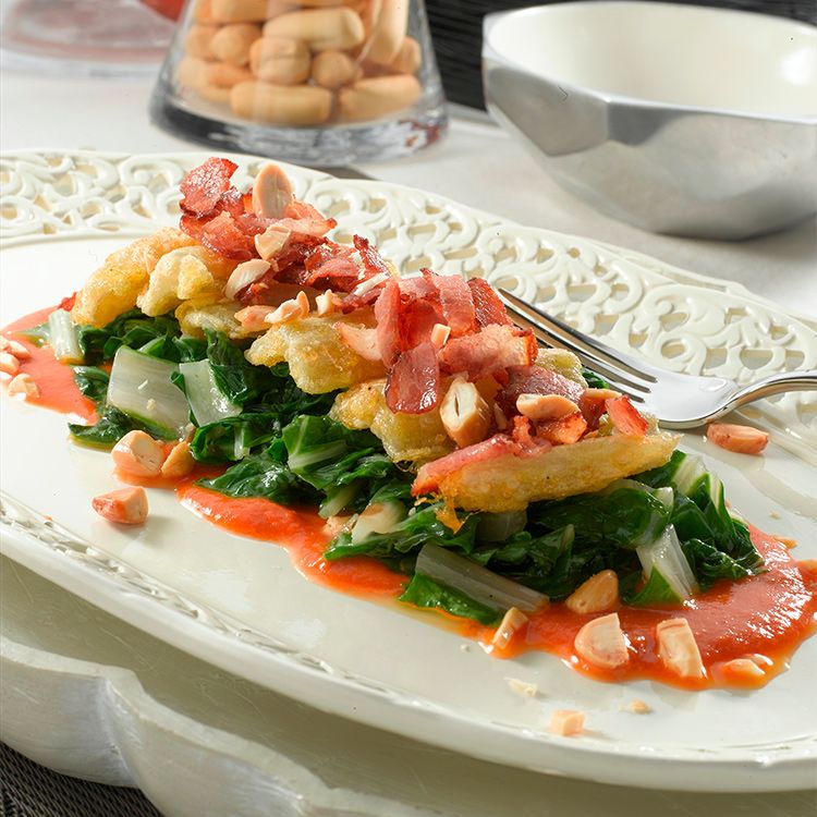 Acelgas cocidas con pencas rebozadas, beicon, tomate y frutos secos