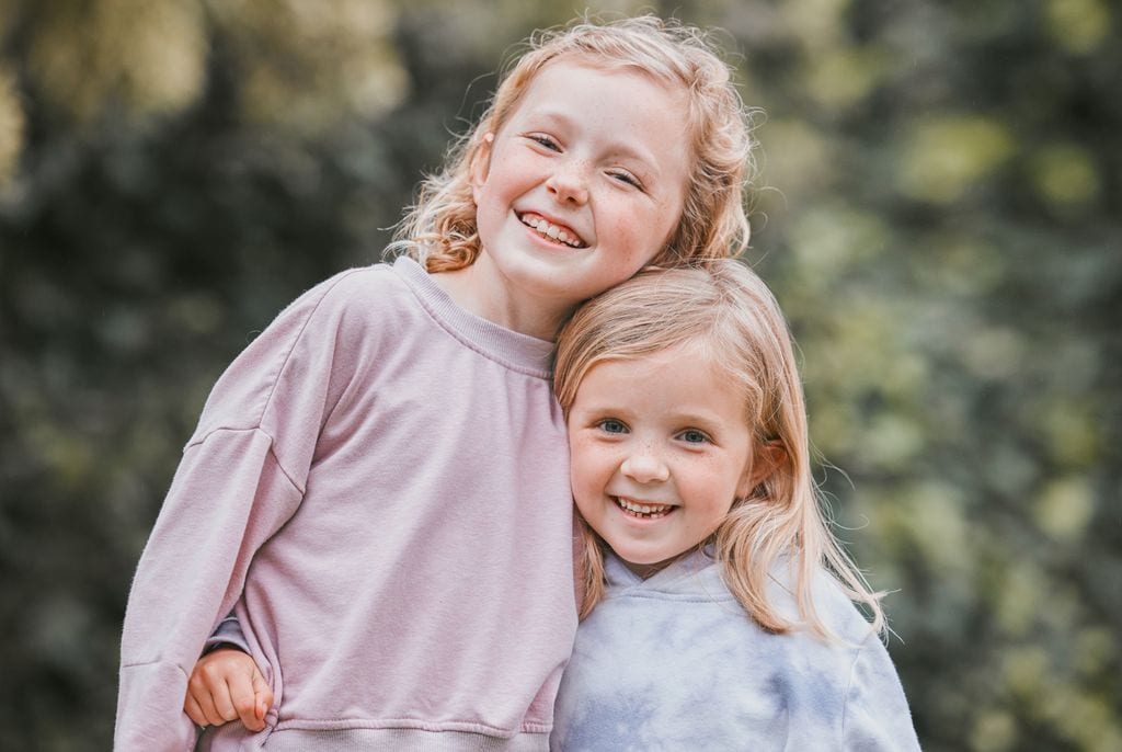 Hermanas abrazándose felices en el exterior