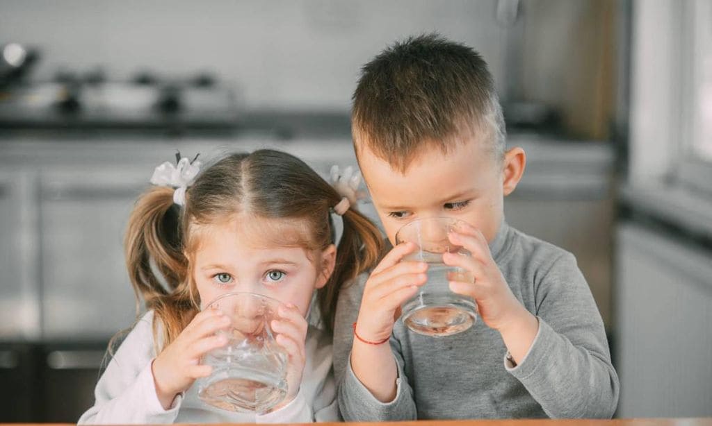 ni os bebiendo agua