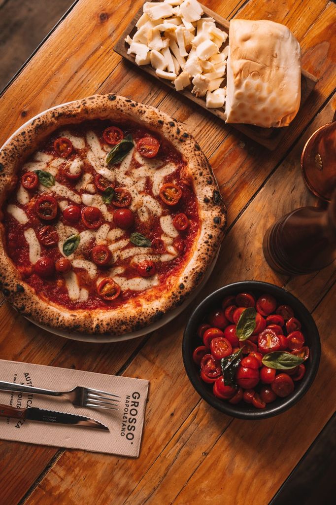 Esta pizza está elaborada con con harina de fuerza italiana, base de tomate San Marzano, cherries al horno de leña, un toque de parmesano y provola fresca ahumada de Latteria Sorrentina.